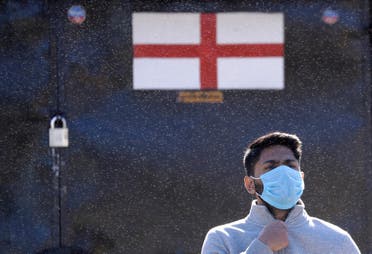 A man wears a protective face mask as he stands in front of a closed souvenir booth in Westminster in London, as the country is in lockdown to help curb the spread of coronavirus on April 21, 2020. (AP)