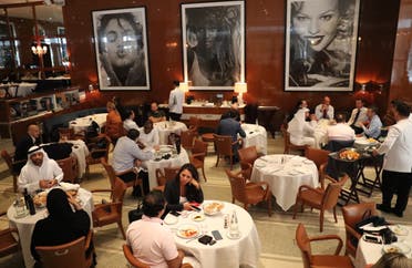 Peope eat at a restaurant in Dubai on August 30, 2018. (AFP)