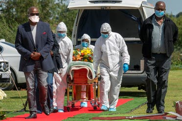 Pallbearers wearing personal protective equipment suits lift the casket containing the remains of a victim of COVID-19 outside Johannesburg, South Africa, on April 16, 2020. (AP)