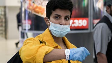 A Kuwaiti woman wearing a protective face mask poses as she shows her quarantine tracking bracelet upon her arrival from Amman to Kuwait Airport, following the outbreak of the coronavirus disease (COVID-19), in Kuwait City, Kuwait April 21, 2020. REUTERS/Stephanie McGehee