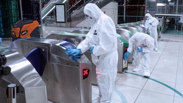 Members of a medical team wearing protective suits clean entry machines, after a curfew was imposed to prevent the spread of the coronavirus disease (COVID-19), in Dubai, United Arab Emirates, March 27, 2020. Picture taken March 27, 2020. Government of Dubai Media Office/Handout via REUTERS ATTENTION EDITORS - THIS PICTURE WAS PROVIDED BY A THIRD PARTY.