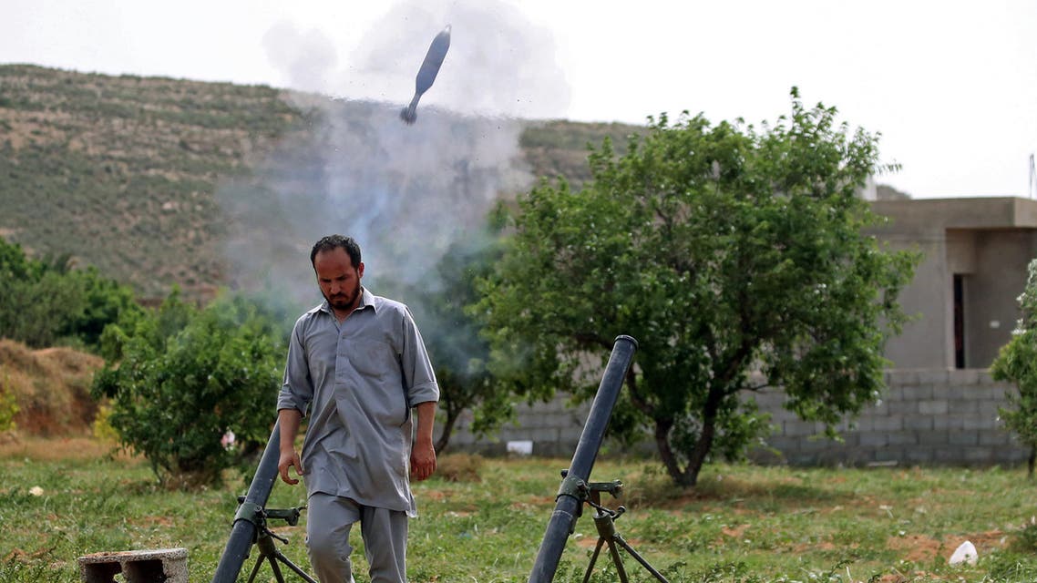 A fighter with Libya's UN-recognised Government of National Accord (GNA) fires rockets from a position near the town of Garabulli toward the city of Tarhuna, southwest of the capital Tripoli, held by the forces of the Libyan strongman Khalifa Haftar, on April 19, 2020.