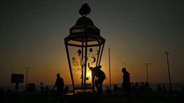 A man installs a giant traditional fanous lantern, a decoration used to celebrate the start of the Muslim holy month of Ramadan, at al-Shati camp for Palestinian refugees in the central Gaza Strip on April 23, 2020. (AFP)