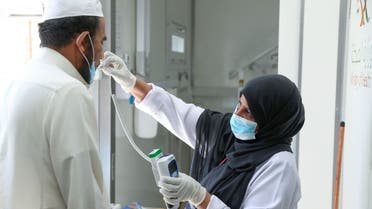 A Saudi nurse checks a patient's temperature at a mobile clinic catering for the residents of Ajyad Almasafi district in the holy city of Mecca, on April 7, 2020, which authorities have sealed-off, along with other major cities, amid measures to curb the spread of COVID-19. Saudi Arabia's health minister warned of a huge spike in coronavirus cases of up to 200,000 within weeks, state media reported, a day after the kingdom extended the duration of daily curfews in multiple cities, including the capital, to 24 hours in a bid to limit the spread of the deadly virus.
