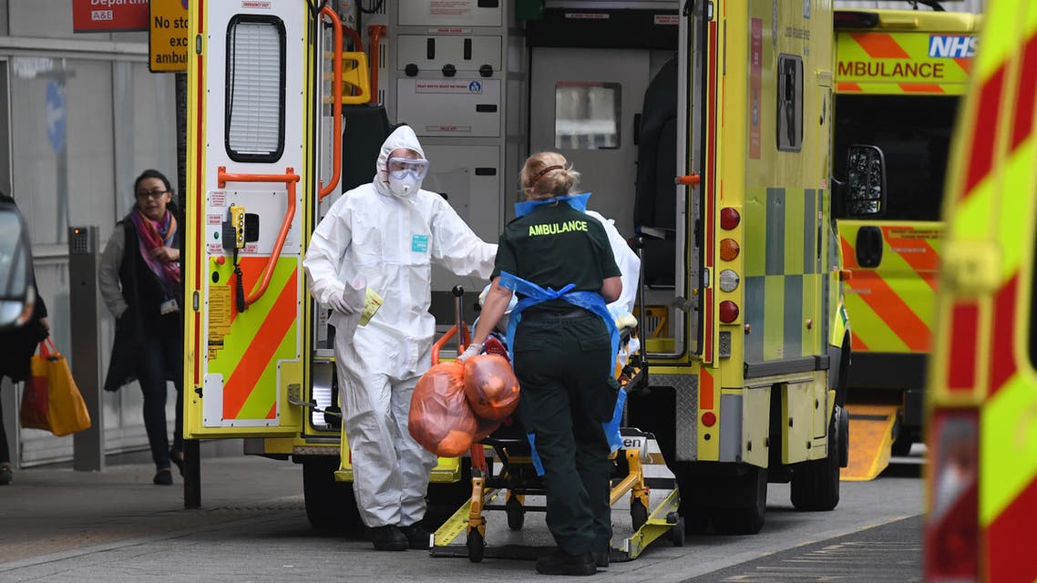 Ambulance staff wearing personal protective equipment (PPE) help a patient from an ambulance into The Royal London Hospital in east London on April 18, 2020. (AFP)