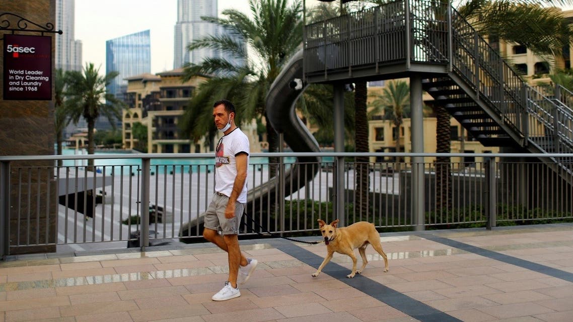 A man with a protective face mask, walks his dog, following the outbreak of coronavirus disease (COVID-19), in downtown Dubai. (Reuters)