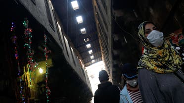 People wearing protective face masks, walk near traditional Ramadan products which are displayed for sale, amid concerns over the spread of the coronavirus disease (COVID-19) at Al Khayamia street in old Cairo, Egypt April 16, 2020. Picture taken April 16, 2020. REUTERS/Amr Abdallah Dalsh