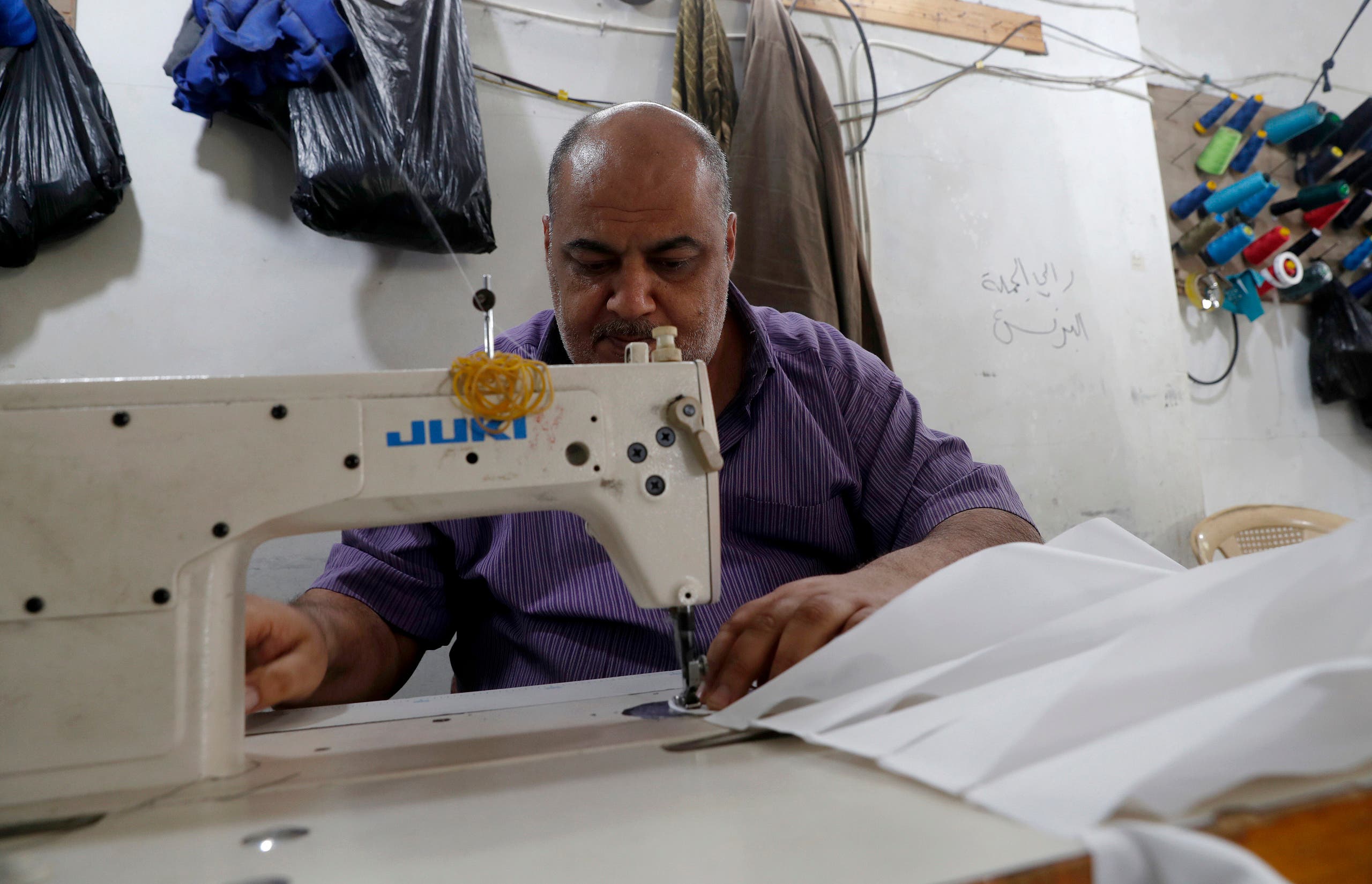 Palestinians make protective overalls to help shield people from the coronavirus, that will be exported to Israel, at a local factory, in Gaza City, Monday, March 30, 2020. (AP)