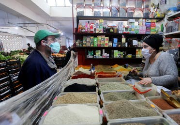 A vendor serves a customer inside her shop amid concerns over the coronavirus in Algiers, Algeria April 19, 2020. Picture taken April 19, 2020. (Reuters)