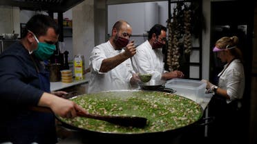 Benito Gomez (2nd L), chef of two-Michelin-starred restaurant Bardal, cooks food with other chefs and volunteers during a food distribution campaign for families following the outbreak of the coronavirus disease (COVID-19), at a social lunchroom in Ronda, southern Spain. (Reuters)