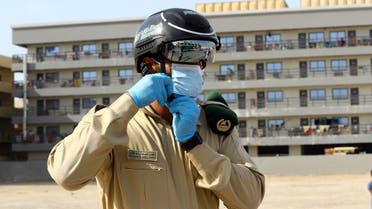 A police officer wears a smart helmet as he uses it to test the temperature of the workers during the outbreak of the coronavirus disease (COVID-19) in Dubai. (Reuters)
