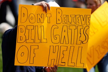 A protester waves a placard against American business magnate and philanthropist Bill Gates during a protest against the stay-at-home order issued by Colorado Governor Jared Polis to stem the spread of the new coronavirus, on April 19, 2020, in Denver. (AP)