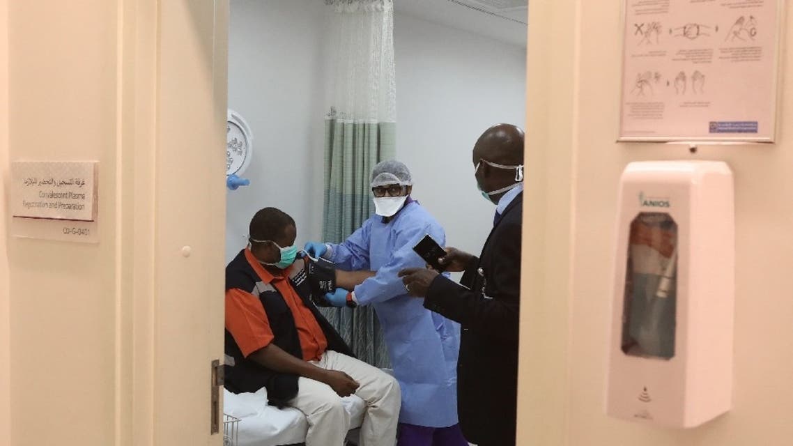 A recovered COVID-19 patient (L) donates convalescent plasma at the Communicable Disease Center of Hamad Medical Corporation (HMC) in the Qatari capital Doha, on April 19, 2020. (AFP)