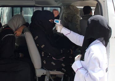A health worker takes temperature of passengers of a van, amid fear of coronavirus disease, on the outskirts of Taiz, Yemen on April 12, 2020. (Reuters) 