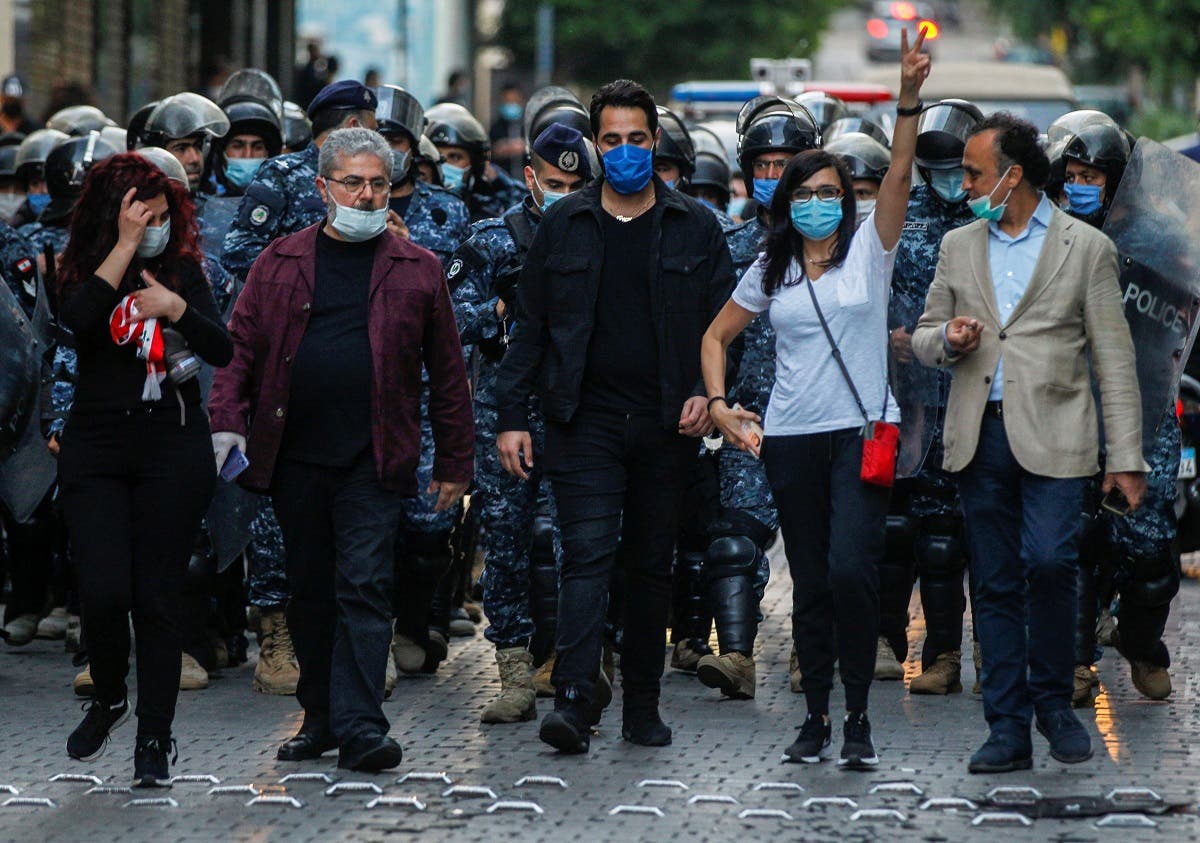 Lebanese demonstrators wear face masks during a protest against the collapsing Lebanese pound currency outside Lebanon's Central Bank in Beirut, Lebanon April 23, 2020. (Reuters)
