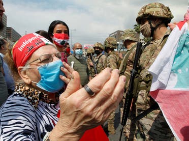 An elderly woman wearing a face mask gestures during a protest against the collapsing Lebanese pound currency and the price hikes, in Zouk, north of Beirut, Lebanon April 27, 2020. (Reuters)