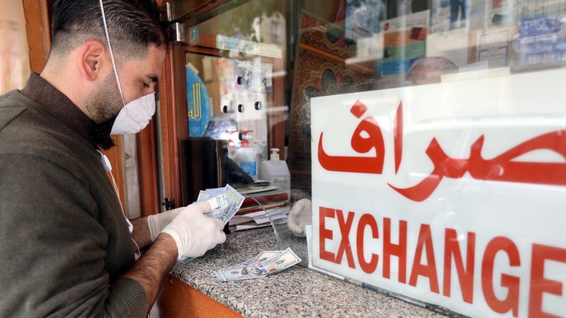 A customer wearing a face mask and gloves, is served at a counter of a currency exchange store, during a countrywide lockdown to combat the spread of coronavirus disease (COVID-19) in Beirut, Lebanon. (Reuters)