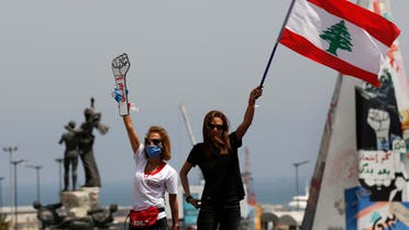 Anti-government protesters stand on the top of their cars and wave a Lebanese flag and a cardboard fist labelled Revolution in Beirut on April 22, 2020. (AP)