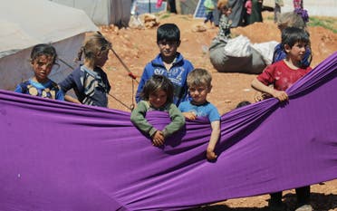 Displaced children take part in an event organzied by Violet Organization, in an effort to spread awareness and encourage safety amid coronavirus disease (COVID-19) fears, at a camp in the town of Maarat Masrin in northern Idlib, Syria April 14, 2020. (Reuters)