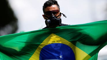 A pro-Bolsonaro protester with a Brazil flag and a gas mask, Brasilia, April 27. (Reuters)