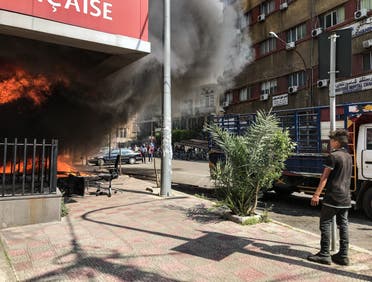 A boy looks on as the Banque Libano Francaise in central Tripoli burns. (Finbar Anderson)