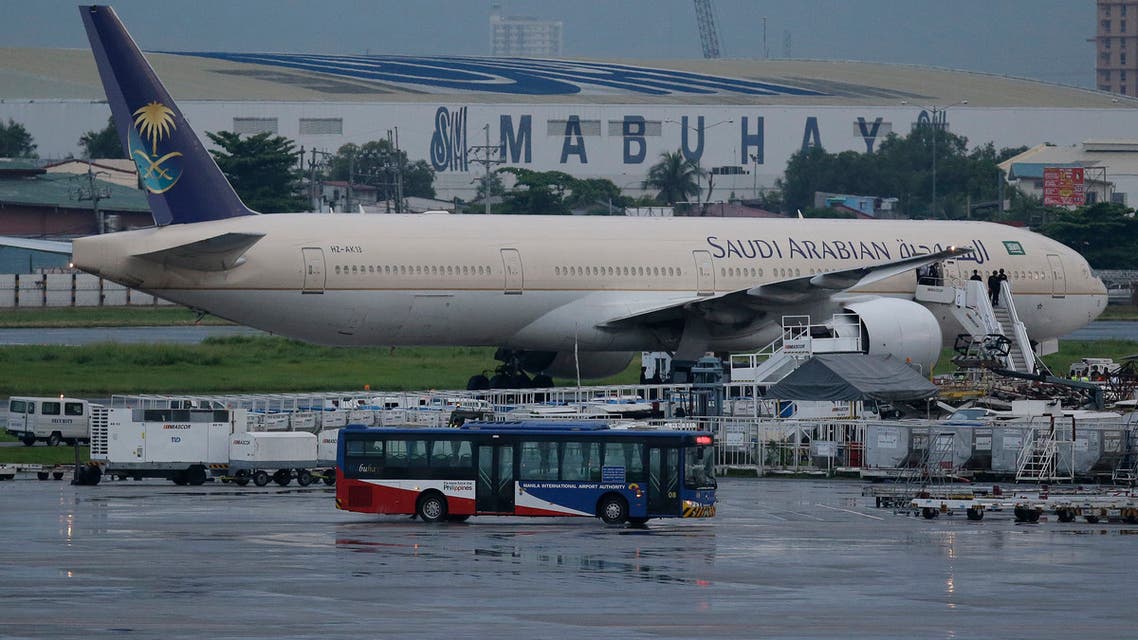 A passenger bus passes by the Saudi Arabian Airlines plane Flight SV872 from Jiddah as it stays at an isolated area at Manila's International Airport in Pasay. (AP)