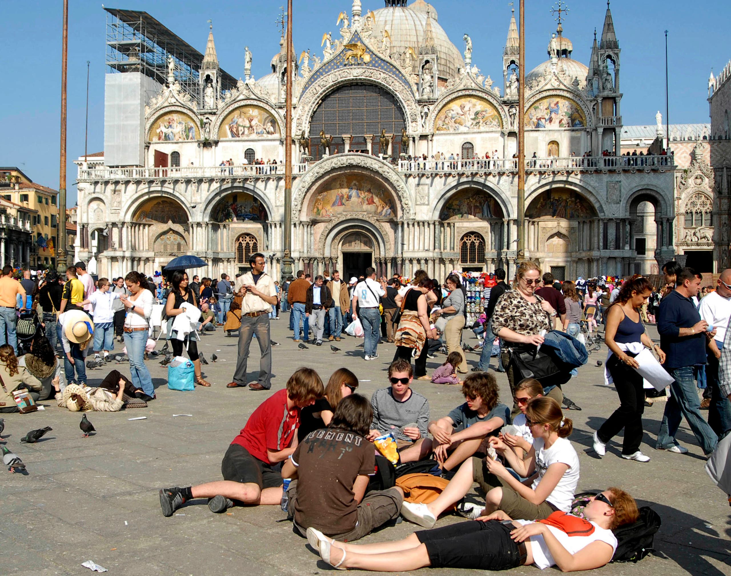 Tourists enjoy the sun in a crowded St.Mark's Square, in Venice, northern Italy, with St. Mark's Basilica in the background, in this May 1, 2007 photo. (AP)