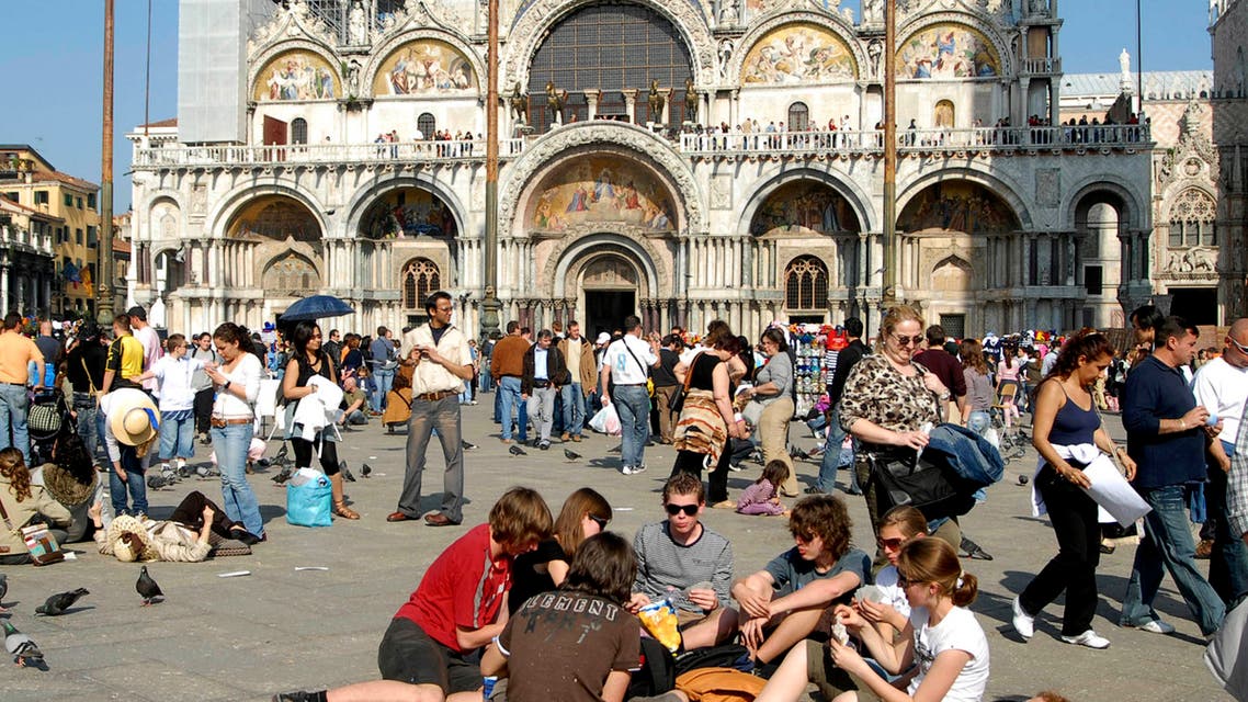 Tourists enjoy the sun in a crowded St.Mark's Square, in Venice, northern Italy, with St. Mark's Basilica in the background, in this May 1, 2007 photo. (AP)