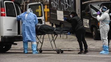NEW YORK, NY - APRIL 27 : A funeral worker is assisted moving a deceased patient into a van at the Brooklyn Hospital Center on April 27, 2020 in the Brooklyn borough of New York City. The Brooklyn Hospital Center has been part of the pandemic's epicenter in New York City. Stephanie Keith/Getty Images/AFP 