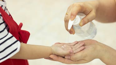 Kid using sanitizer alcohol gel clean hand protection infection virus bacteria cleanser stock photo