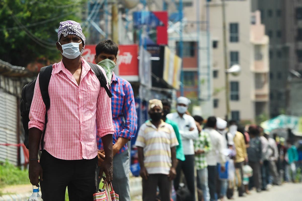 Migrant laborers queuing to board a government bus to return to their homes during an imposed nationwide lockdown to curb the coronavirus in Kolkata on April 29, 2020. (AFP)