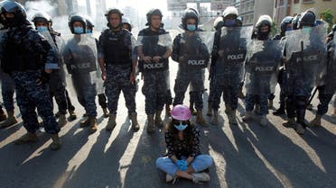 A demonstrator sits on the ground in front of Lebanese police officers during a protest against growing economic hardship in Beirut, Lebanon April 28, 2020. (Reuters)