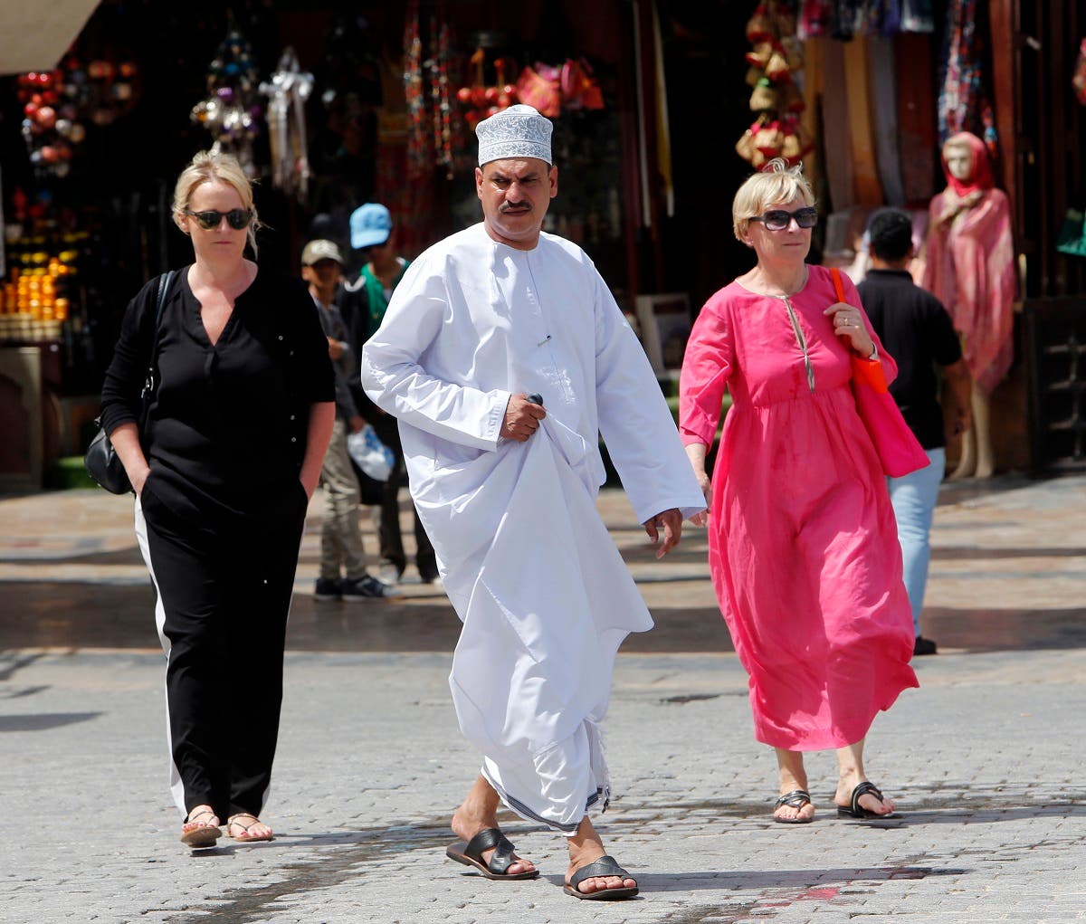 People walk on a street on March 18, 2015 in the Omani capital, Muscat. (AFP) 