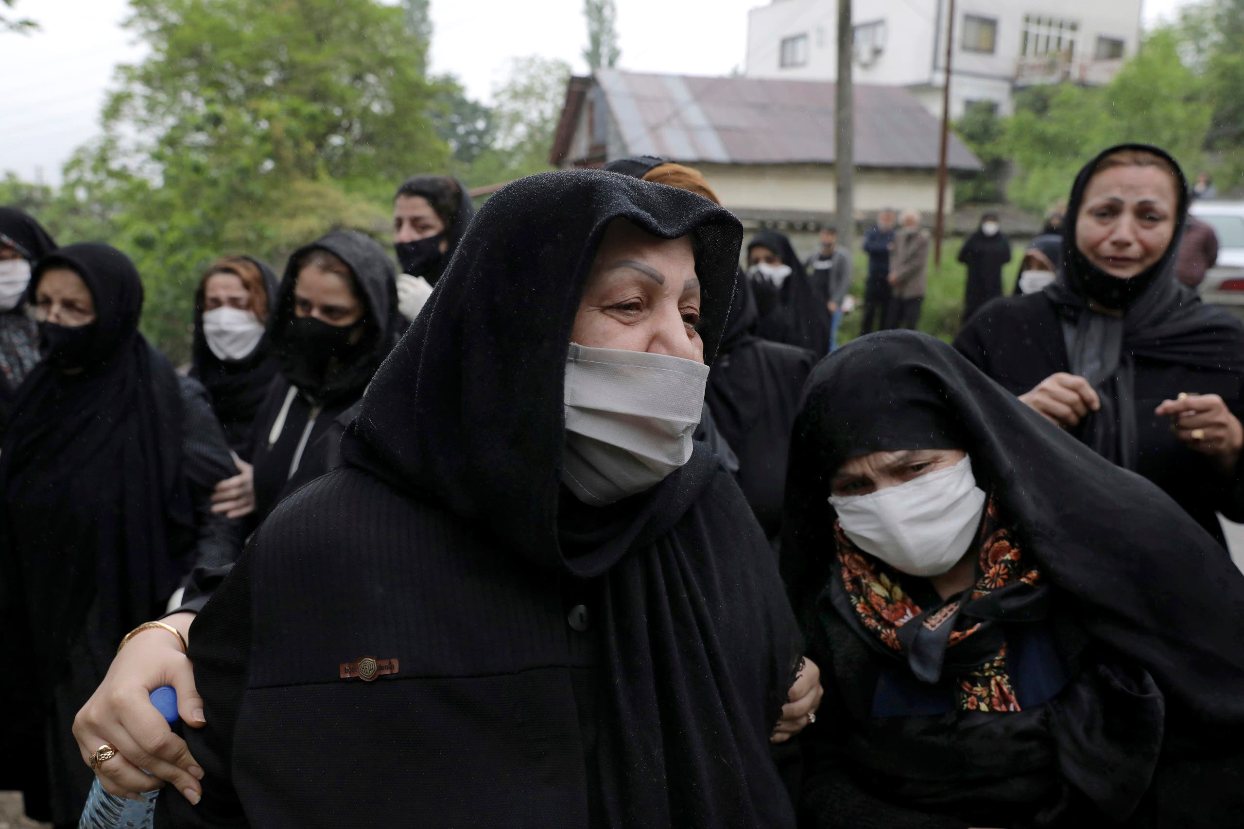 Relatives of a victim who died from the new coronavirus, mourn at the gate of a cemetery in the city of Ghaemshahr, in north of Iran on April 29, 2020. (AP)