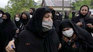 Relatives of a victim who died from the new coronavirus, mourn at the gate of a cemetery in the city of Ghaemshahr, in north of Iran on April 29, 2020. (AP)