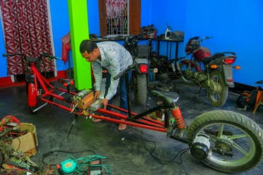 Self-made automobile engineer Partha Saha assembles his modified bike designed for social distancing as a preventive measure against the spread of the COVID-19 coronavirus inside his garage at his house, in Aralia village on the outskirts of Agartala. (AFP)