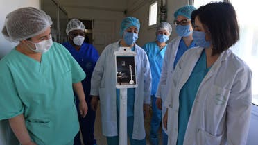 The medical staff at the Mami hospital interact with a robot, manufactured by a Tunisian company and donated to the hospital to support their efforts in combatting the coronavirus (COVID-19) pandemic, in a hallway in the hospital in the city of Ariana north of the Tunisian capital Tunis, on May 1, 2020. 