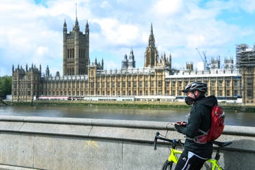 A man stands with his bike, on the south bank of the River Thames in London. (File photo: AP)