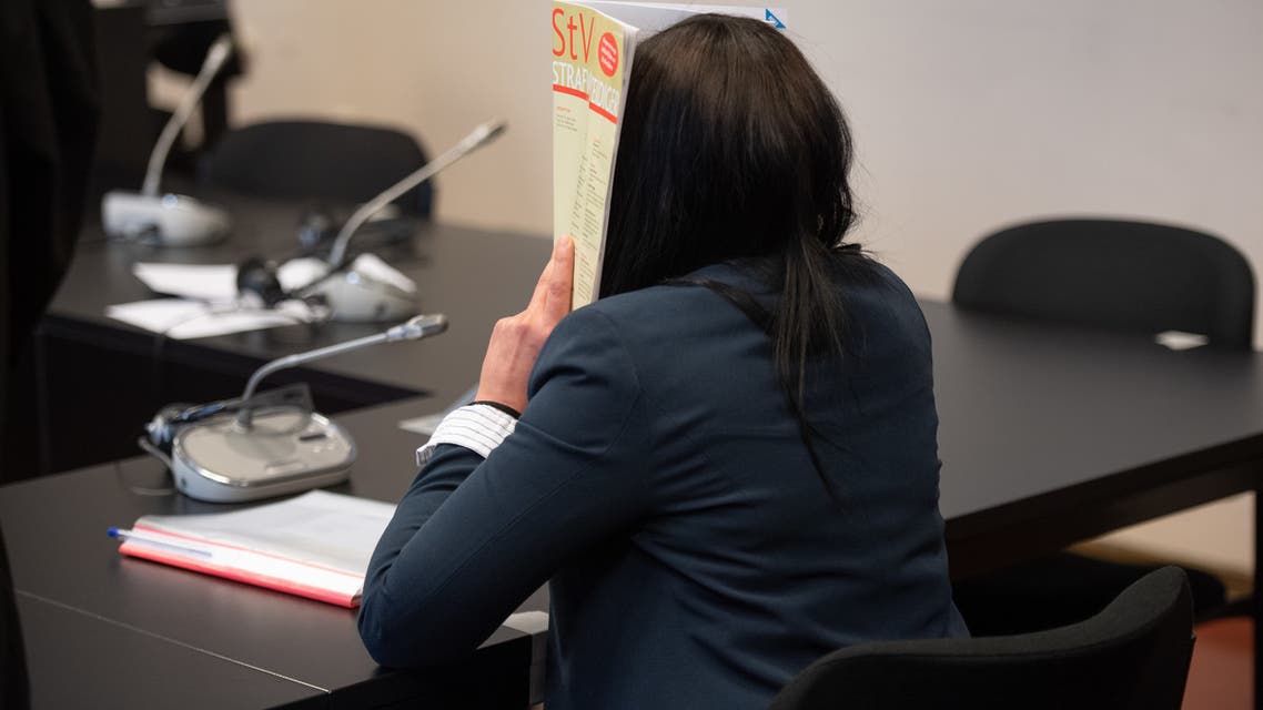Omaima M., a German-Tunisian woman who married a German rapper turned Islamic State fighter and who kept a child slave in Syria, hides her face in the courtroom before the start of her trail on May 4, 2020 at the higher regional court in Hamburg. Omaima M., 35, well-known in Germany for having been the wife of the late German-Ghanaian rapper and IS jihadist Denis Cuspert (aka Deso Dogg), appears before the court on a slew of charges including membership of a foreign terror group, human trafficking and crimes against humanity.