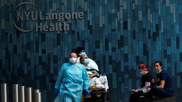 Health workers move a patient wearing a face mask at the at NYU Langone Hospital, during the outbreak of the coronavirus disease (COVID-19) in the Manhattan borough of New York City. (Reuters)