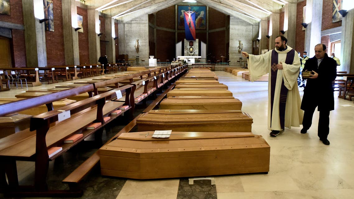 A local priest blesses coffins that have been piling up in a church due to a high number of deaths, before they are taken away by military trucks, as Italy struggles to contain the spread of coronavirus disease (COVID-19), in Seriate, Italy March 28, 2020. REUTERS/Flavio Lo Scalzo