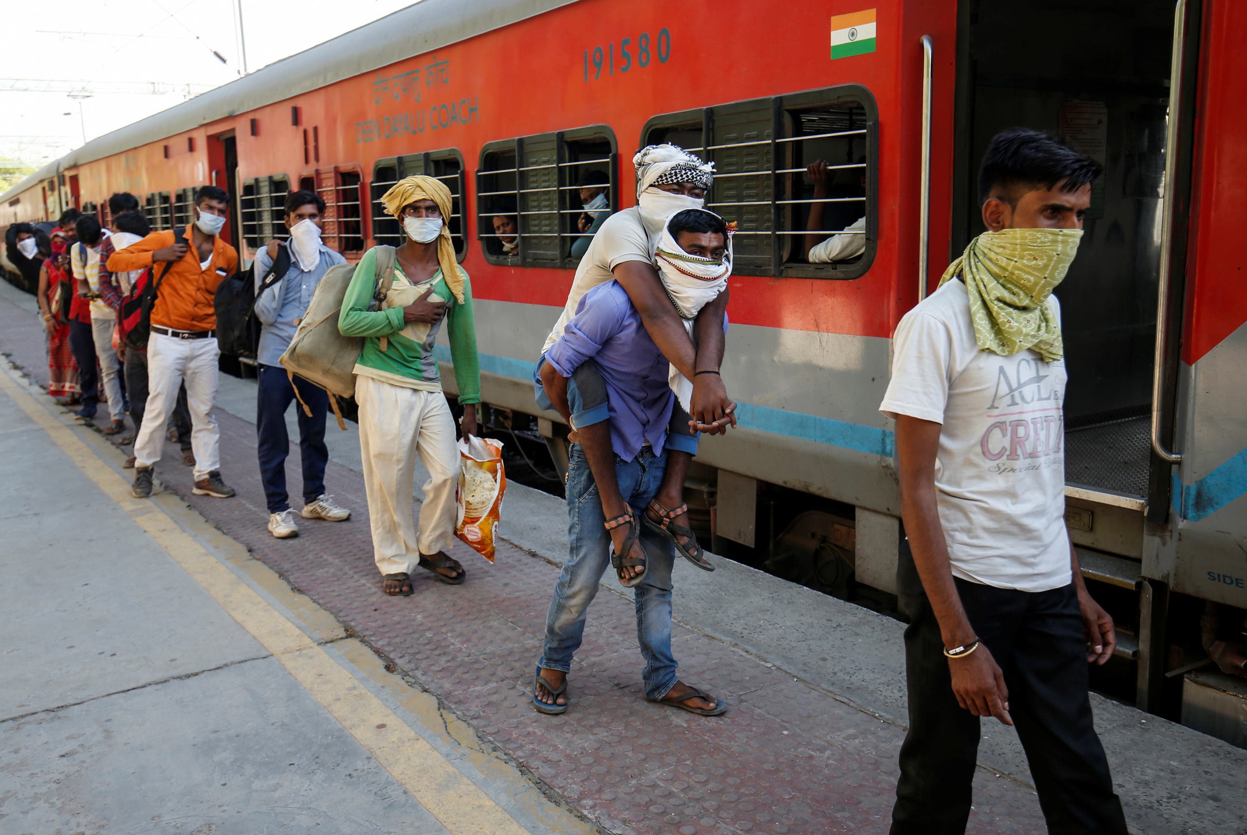 Migrant workers, who were stranded in the western state of Gujarat due to a lockdown imposed by the government to prevent the spread of coronavirus disease (COVID-19), wait to board a train at a railway station In Ahmedabad to leave for their home state of Uttar Pradesh, India. (Reuters)