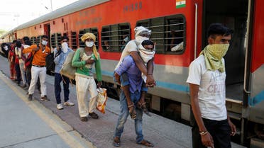 Migrant workers, who were stranded in the western state of Gujarat due to a lockdown imposed by the government to prevent the spread of coronavirus disease (COVID-19), wait to board a train at a railway station to leave for their home state of Uttar Pradesh, in Ahmedabad, India. (Reuters)