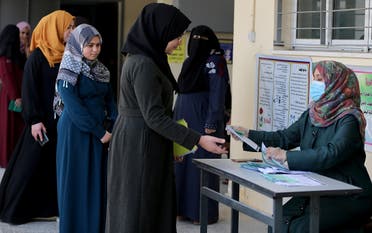 Palestinian high school students receive exam seating card information amid concerns about the spread of the coronavirus disease, in Gaza. (Reuters)
