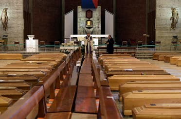 A local priest blesses coffins that have been piling up in a church due to a high number of deaths, before they are taken away by military trucks, as Italy struggles to contain the spread of coronavirus disease (COVID-19), in Seriate, Italy March 28, 2020. (Reuters)