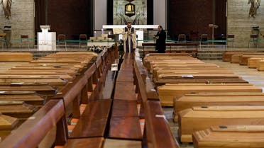 A local priest blesses coffins that have been piling up in a church due to a high number of deaths, before they are taken away by military trucks, as Italy struggles to contain the spread of coronavirus disease (COVID-19), in Seriate, Italy March 28, 2020. REUTERS/Flavio Lo Scalzo