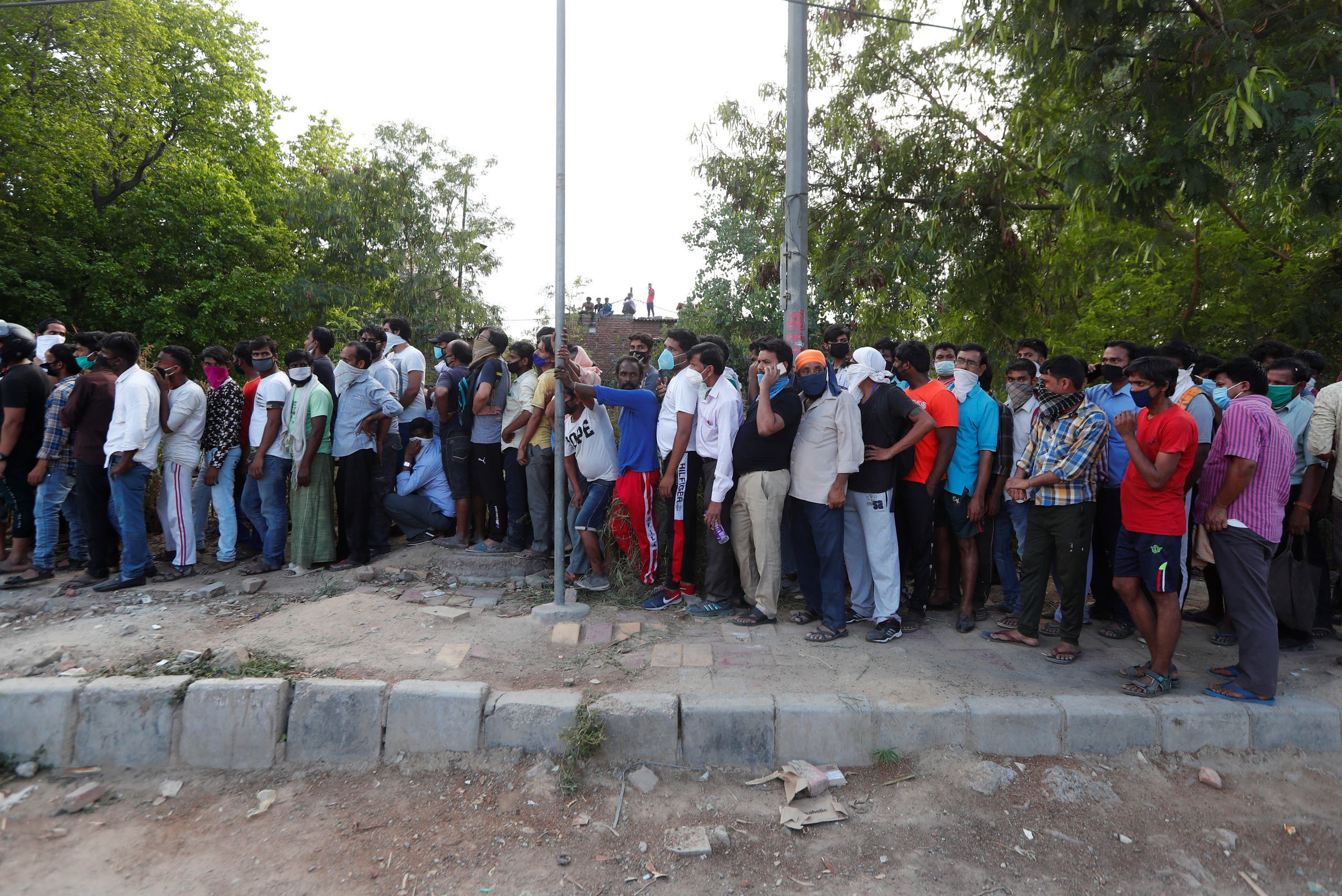 People queue outside a wine store to buy liquor during an extended nationwide lockdown in New Delhi. (Reuters)
