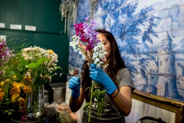 MJ Javan, prepares bouquets of flowers at the flower shop She Loves Me DC after they received an influx of orders during the coronavirus epidemic on March 20, 2020, in Washington. (AP)