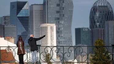 A couple watch the business district of La Defense outside Paris, Thursday, March 12, 2020. (AP)