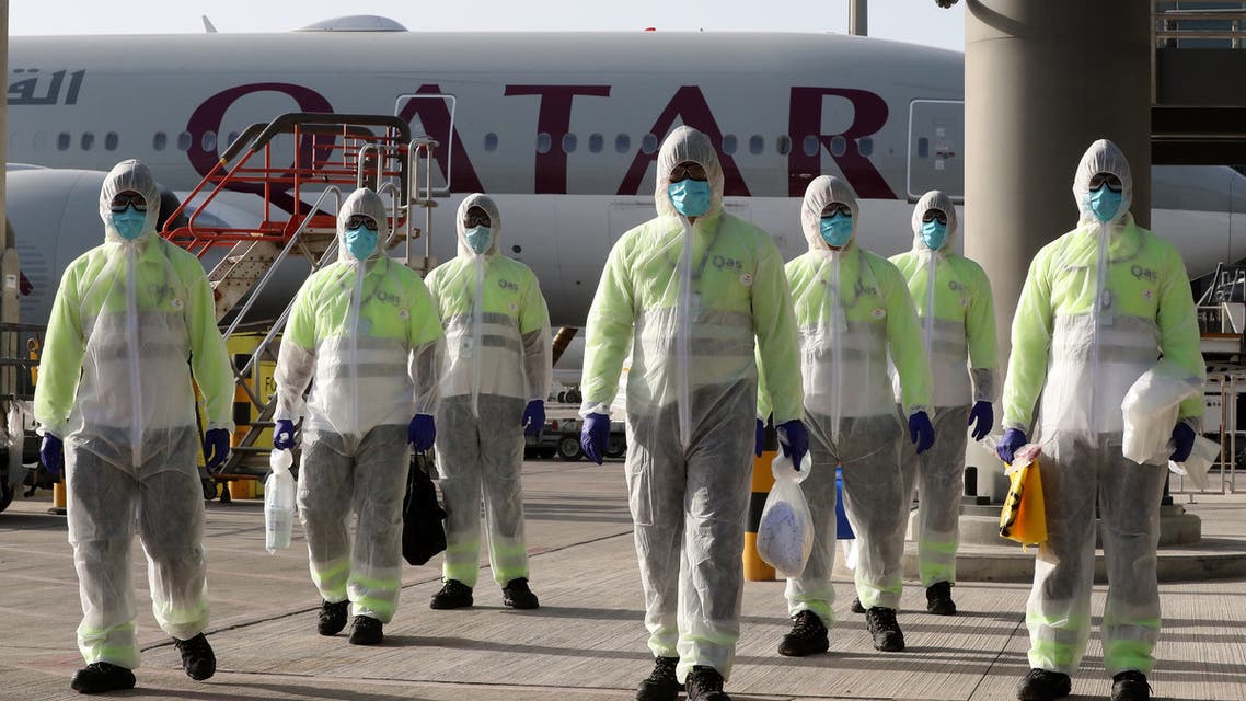 , wemployees of Qatar Aviation Services (QAS)earing protective gear as a safety measure during the COVID-19 coronavirus pandemic, walk along the tarmac after sanitising an aircraft at Hamad International Airport. (AFP)